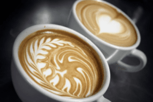close up shot of coffee cups with a heart and leaf design